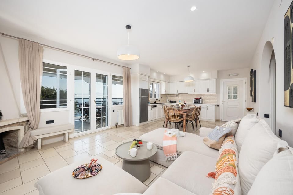 Upper unit: open-plan living room with sofa, dining area, kitchen, ornamental fireplace, WiFi internet, and satellite TV