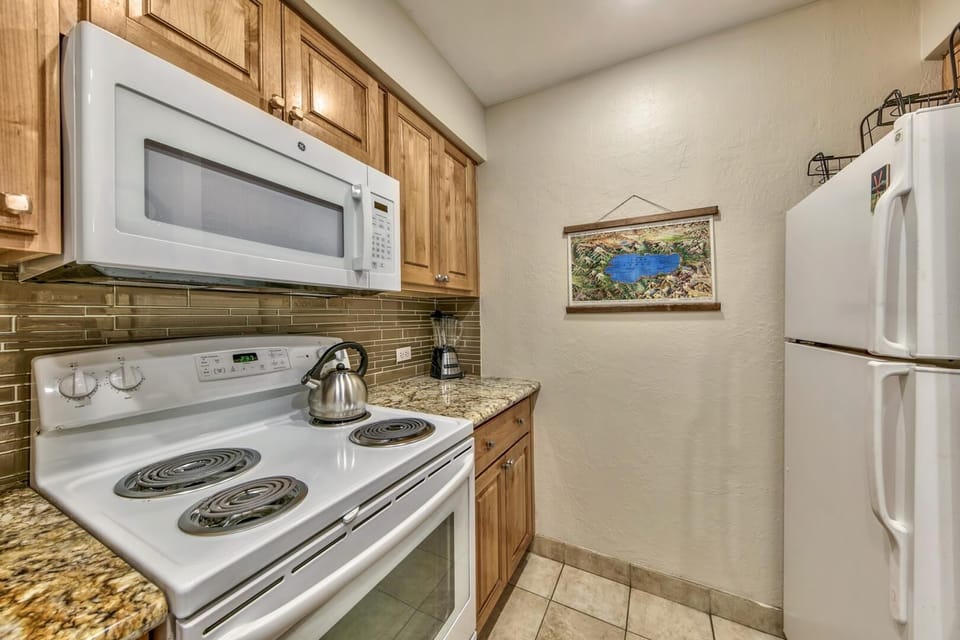 Your fully equipped kitchen features granite countertops, stainless steel appliances, and warm wood cabinetry for all your culinary needs.