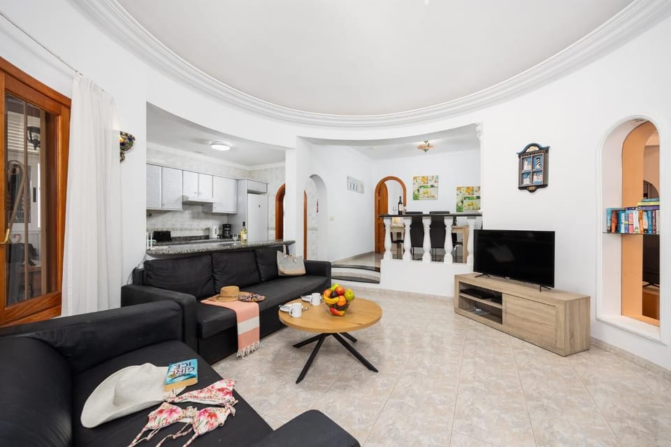 Open-plan living room with sofas, dining area, kitchen, WiFi internet, and satellite TV