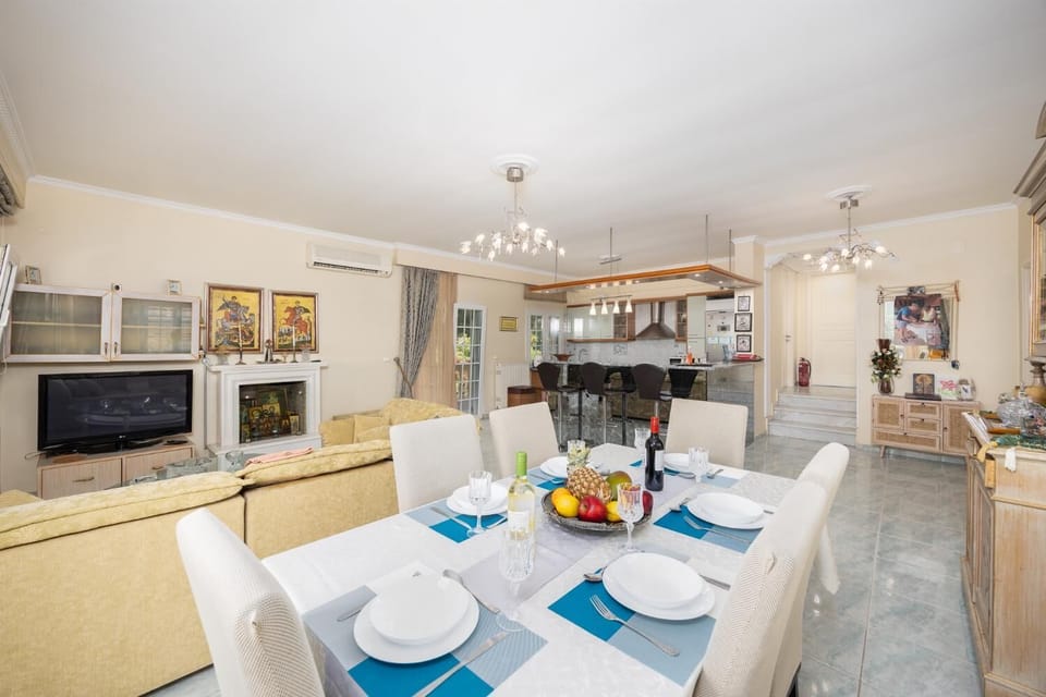 Open-plan living room with sofa, dining area, kitchen, ornamental fireplace, A/C, WiFi internet, and satellite TV
