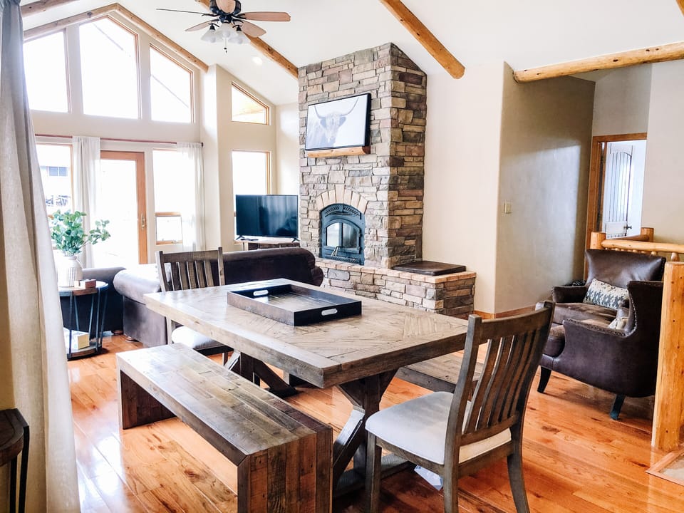 Large, rustic dining table seats 8. There are 4 bar stools at the kitchen island