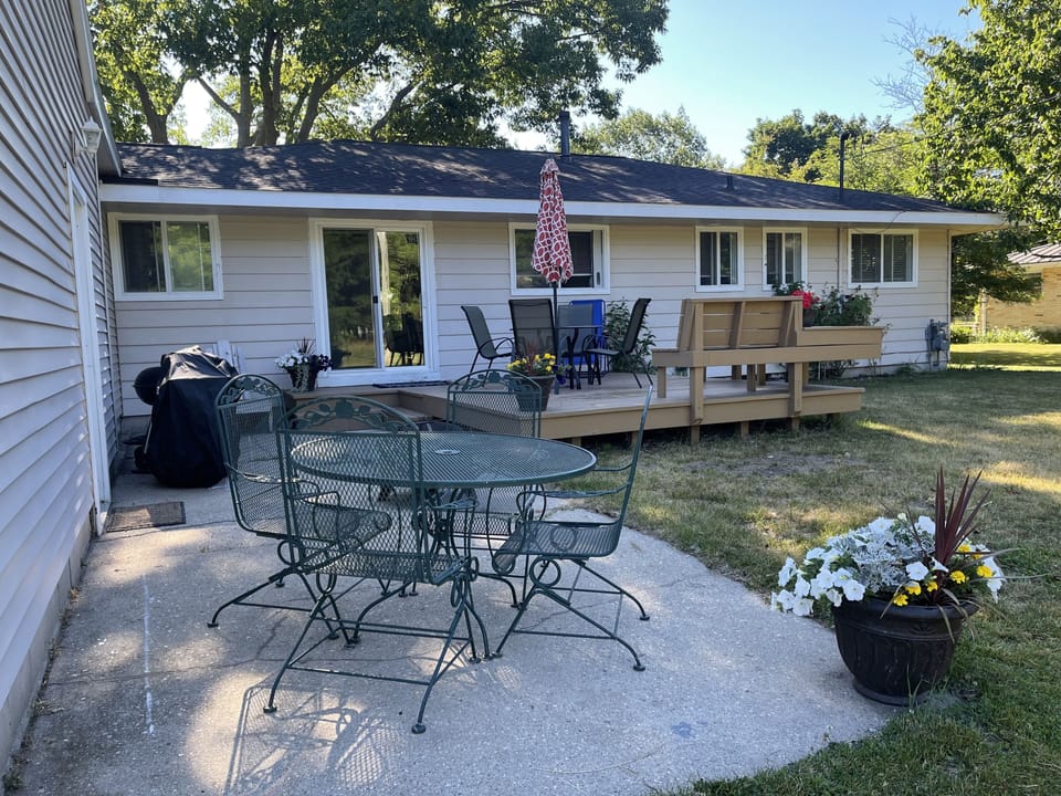 Outdoor space with two tables, benches, gas and charcoal grill.