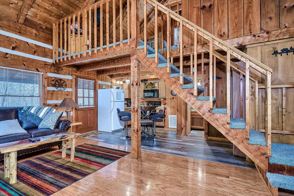 Looking through the living room toward the kitchen and loft above