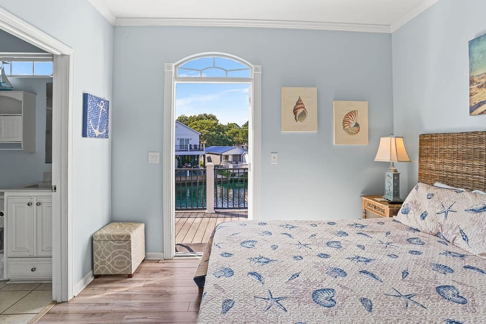 Cozy bedroom with balcony views and coastal charm