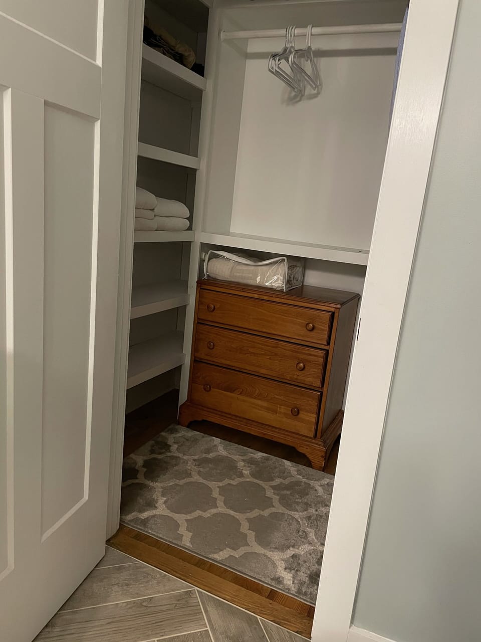Master walk-in closet with shelves and chest of drawers