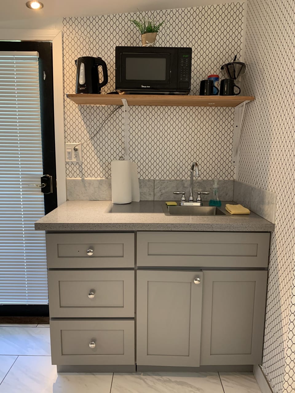 Kitchenette: sink, micro, water pot and dishes with silverware. 