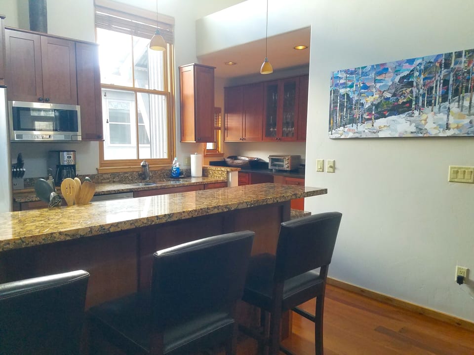 stainless appliances in kitchen with breakfast counter and barstools