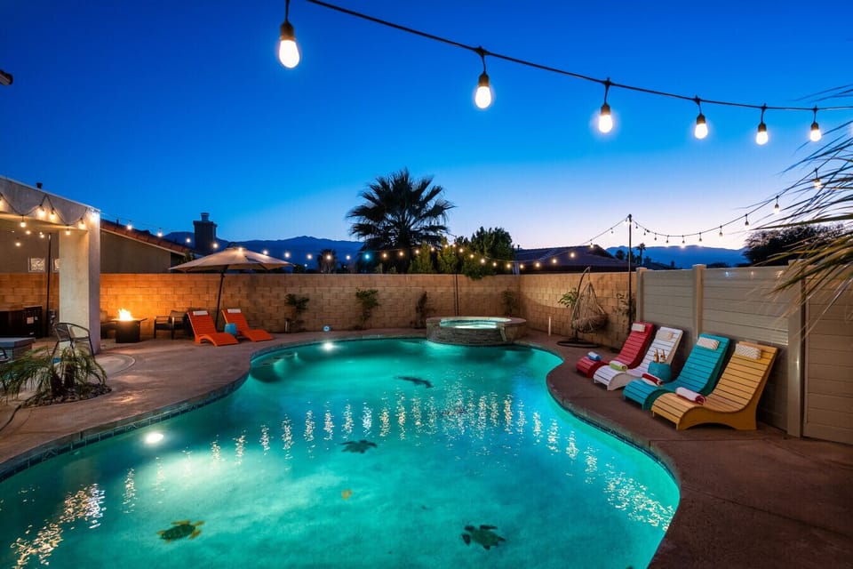 Pool side: large pool and spa, sun loungers with cantilever umbrellas, and outdoor fire pit