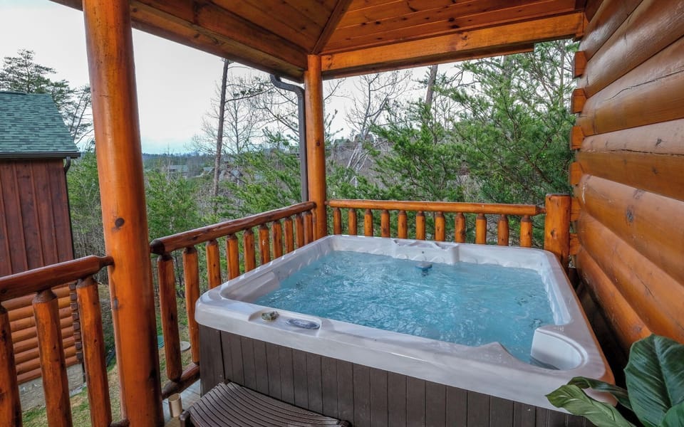 Relax in the hot tub on the covered deck with serene wooded views.
