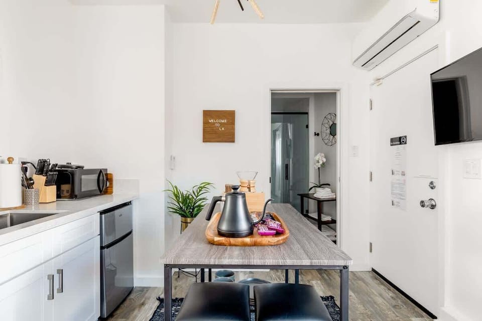 Enjoy the convenience of a sleek, modern kitchenette equipped with a mini-fridge, microwave, and a stylish breakfast bar perfect for your morning coffee or a quick bite.

