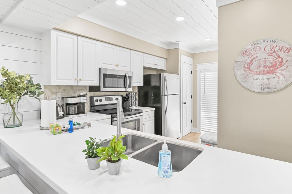 This refreshed kitchen brings a modern coastal feel—bright, airy, and perfect for whipping up a quick breakfast before hitting the beach.