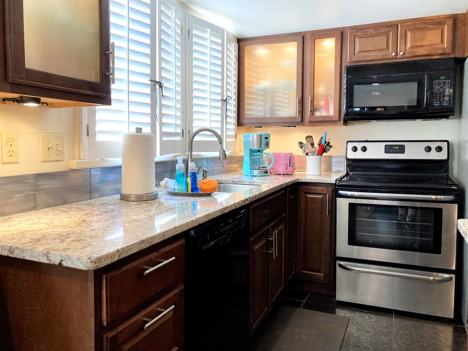 kitchen has Bosch dishwasher, full appliances, granite, coffee maker . . . 

