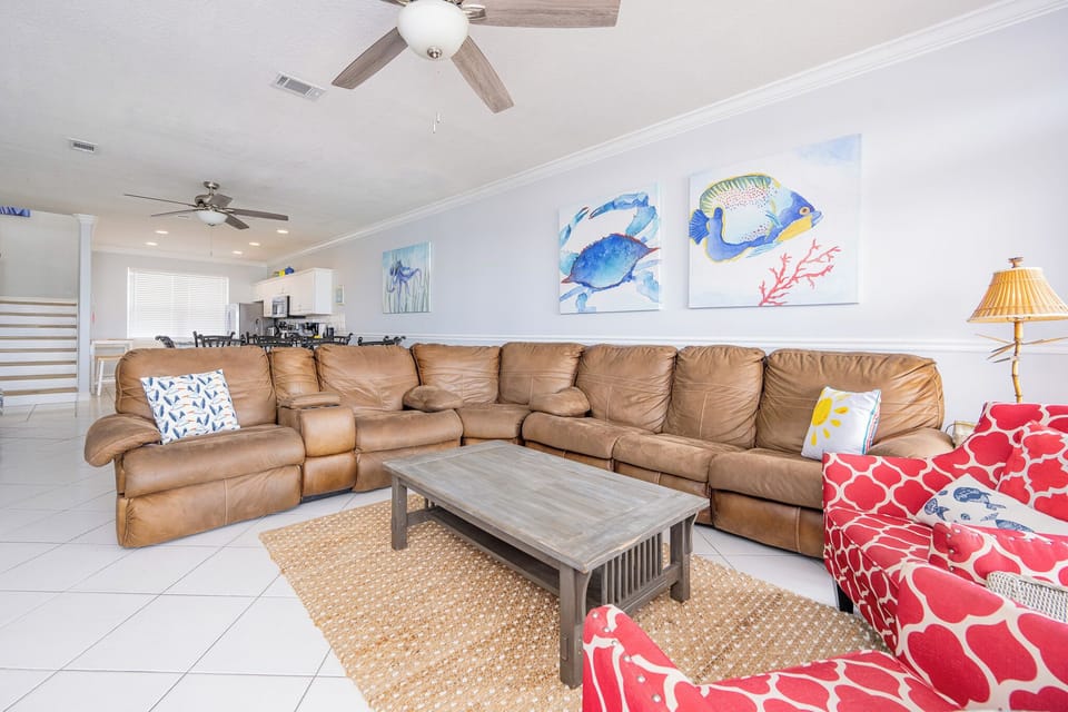 Leather seating invites your family to gather in the living room surrounded by coastal art and soft lamp light