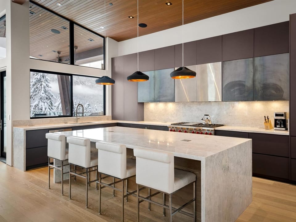 Spacious kitchen with waterfall stone island and 4 seats at the bar.  Stainless appliances