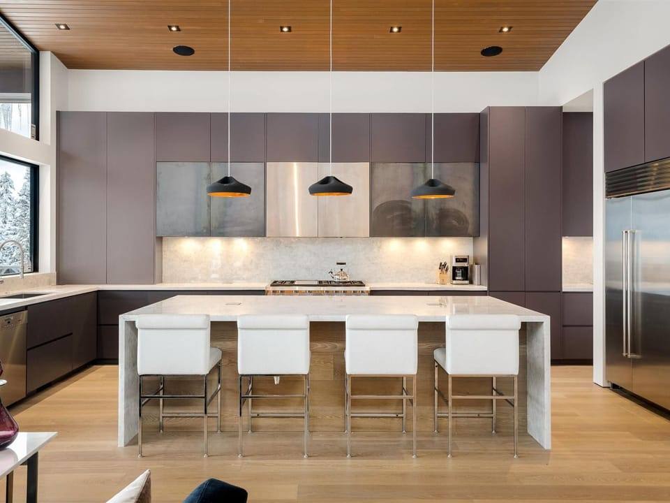 Spacious kitchen with waterfall stone island and 4 seats at the bar.  Stainless appliances