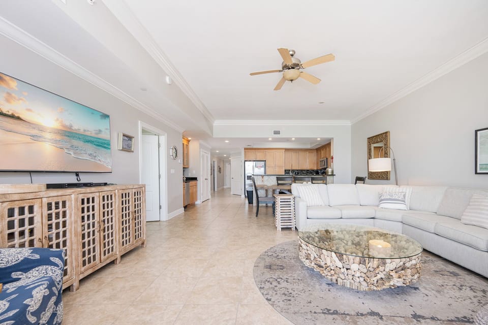 Relax in the inviting living area, featuring a spacious sectional sofa and coastal-inspired coffee table