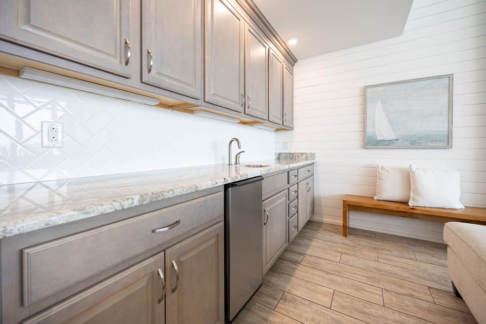 Prepare refreshing drinks at the wet bar, enjoying the beachy atmosphere as you unwind in this inviting space