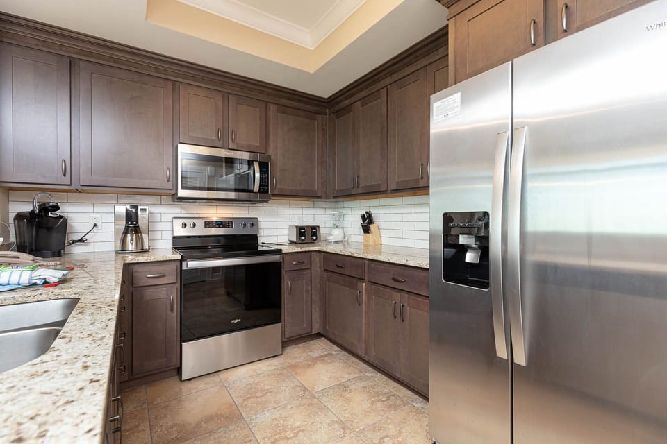 Create delicious meals in this kitchen, equipped with stainless appliances, rich wooden cabinetry, and coffee corner