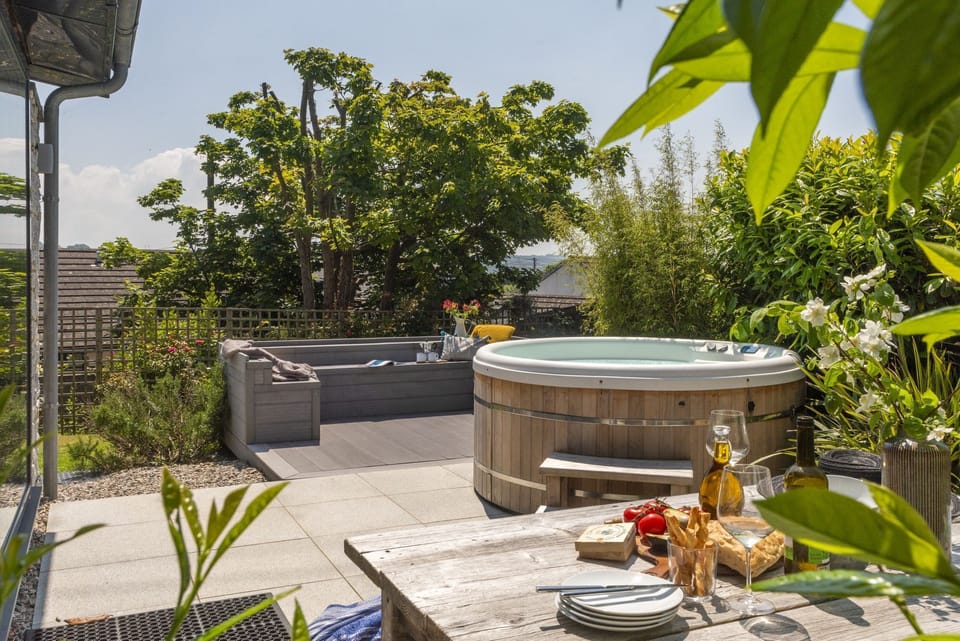 Patio area with hot tub and seating, outside dining table - 6 The Dunes, Upton Towans