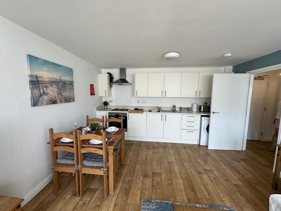 Spacious kitchen with white cabinetry, built-in oven, and adjacent wooden dining table – Castle 10 - Southampton