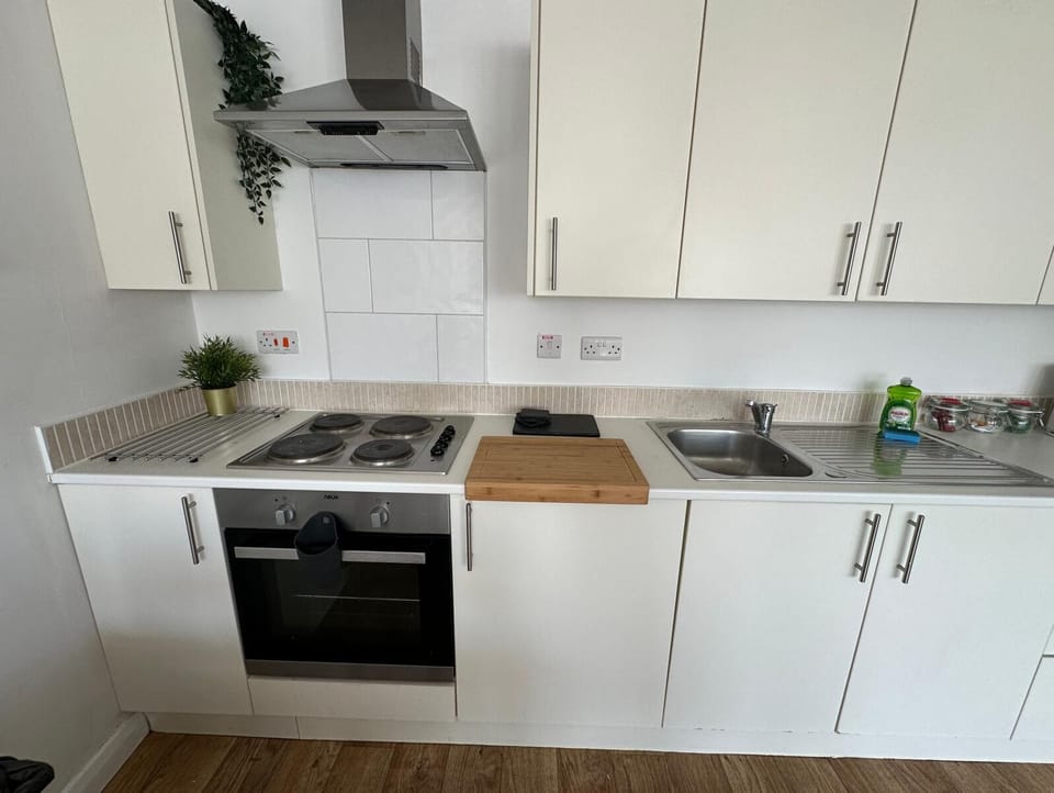 Contemporary kitchen with white cabinets, oven, cooktop, extractor hood, and kitchen counter – Castle 10 - Southampton