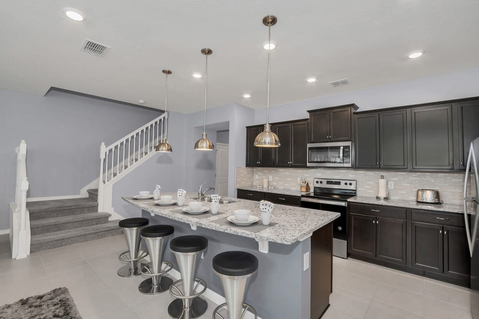 The kitchen, complete with a counter bar table, transforms into a social hub where culinary delights and conversations intertwine. A versatile space where meals are prepared with ease and shared moments become treasured memories.
