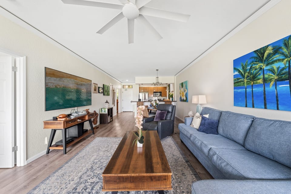 Sectional sofa and coastal art widen the view, wood furniture tying the room together.