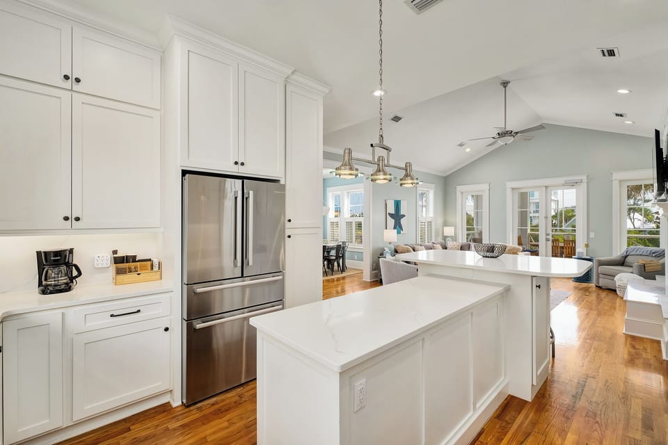Your bright, modern kitchen features pristine white cabinets, marble countertops, and stainless steel appliances—perfect for preparing meals during your stay.