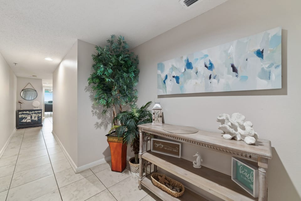 The soft hues of the beach-themed artworks complement the serene and inviting atmosphere of the interior space.