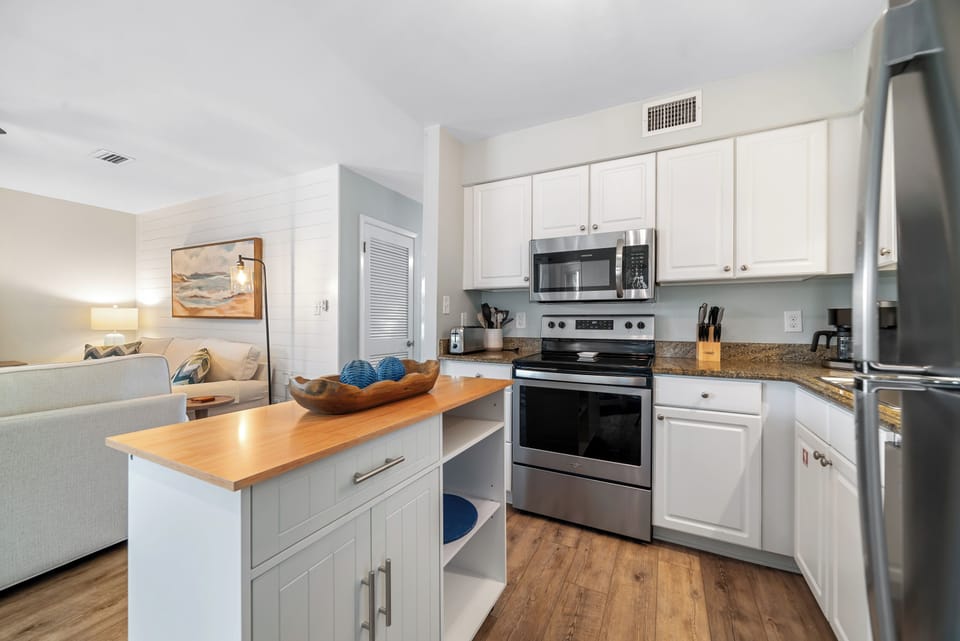 Stainless steel appliances, ample counter space, and a charming kitchen island define this functional kitchen.