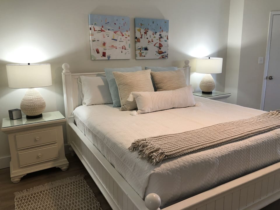 Master bedroom with king bed, reading nook, and 65” smart TV