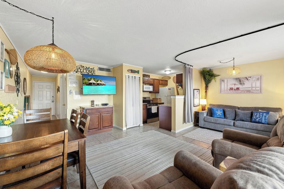Settle into your spacious living area with plush seating, beachy decor, and an open layout that flows effortlessly into the dining space and well-equipped kitchen—perfect for gathering after a day of exploring.