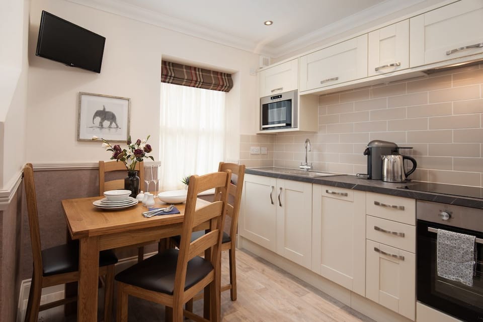 Eildon View - dining area with seating for four and small wall-mounted TV