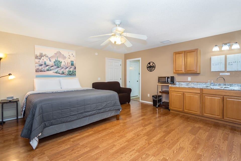 Bedroom one with king size bed, couch and kitchenette area 
