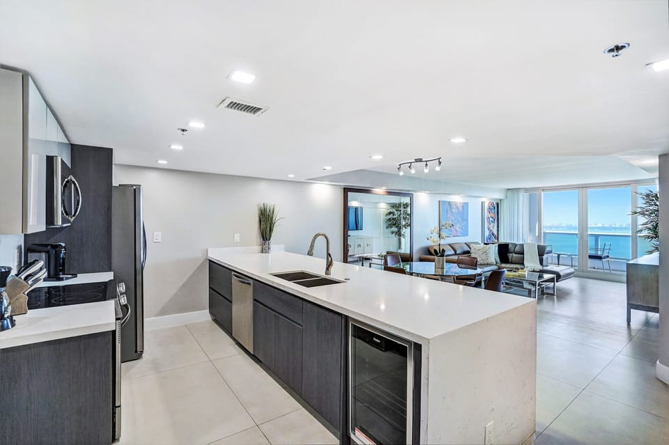 Fully equipped kitchen, dining area, living room with balcony access