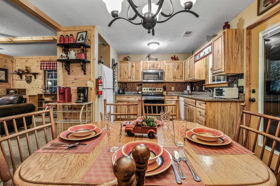 Charming dining table with rustic cabin décor and seating for four at Amazing Dreams cabin in Sevierville, Tennessee — just minutes from Pigeon Forge.