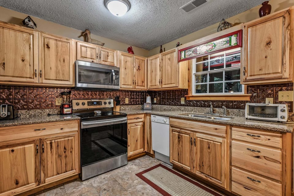 Well-stocked kitchen with hickory cabinetry, stove, microwave, and dishwasher at Amazing Dreams cabin in Sevierville, Tennessee — just minutes from Pigeon Forge.