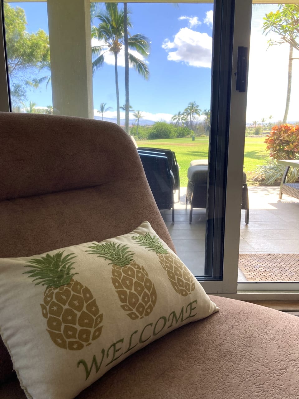 Living room looks out thru large windows to the lanai and expansive golf course