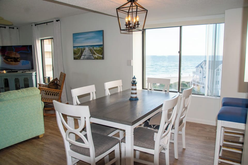 Table for 6 with Ocean View and 2 barstools at Bar top looking into kitchen.