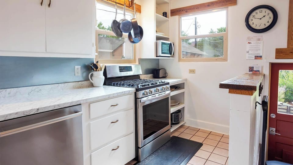 Fully equipped kitchen with gas stove, marble counters, and vintage touches at this historic Kanab adobe rental.