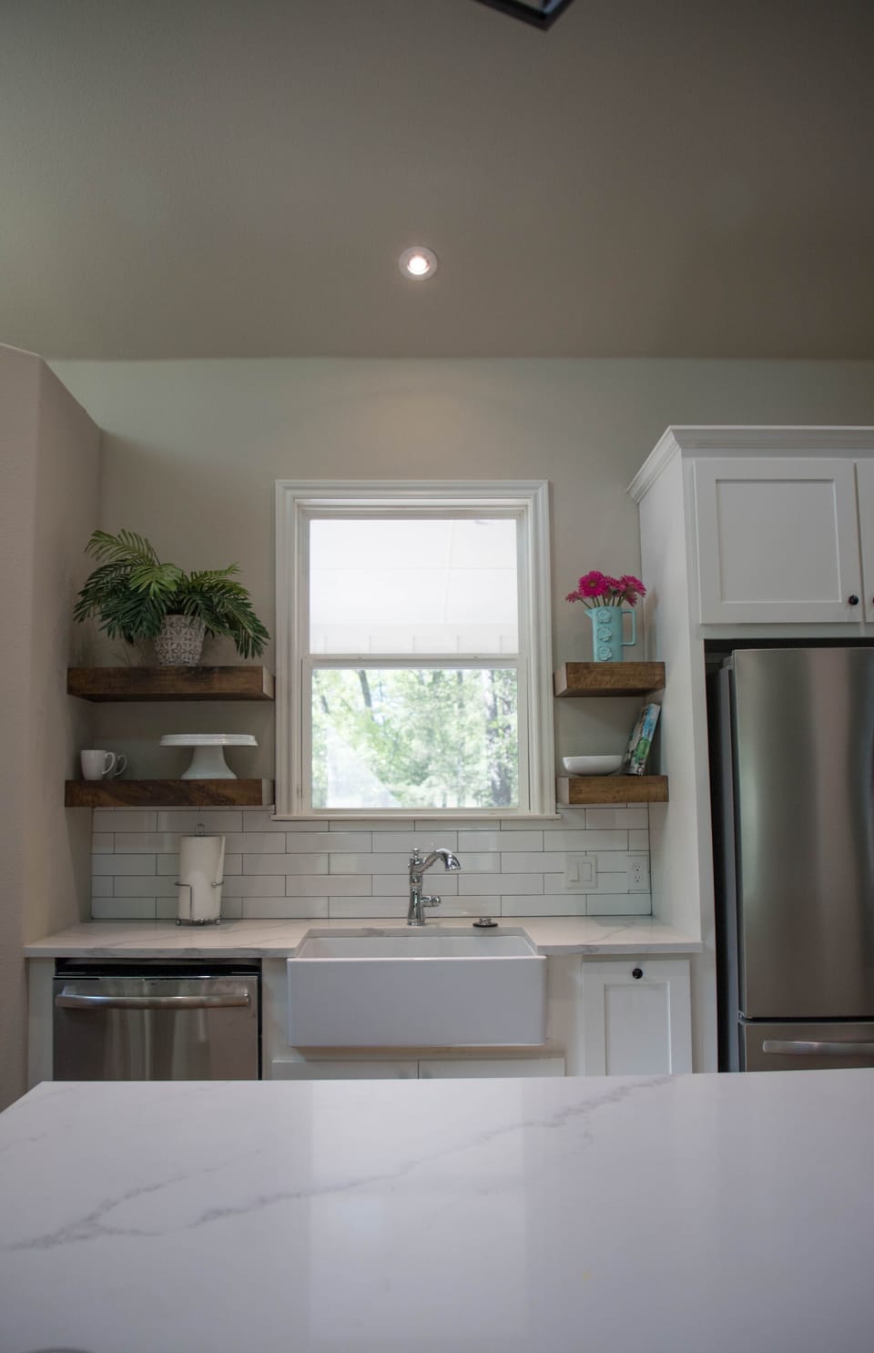 XL sink and floating shelves with views of trees.