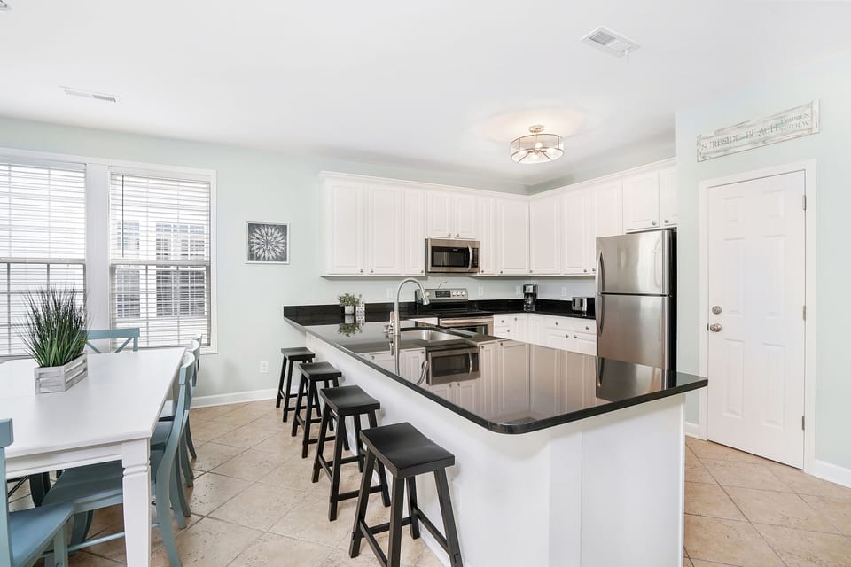 Your spacious kitchen welcomes you with gleaming granite counters, stainless appliances, and a breakfast bar perfect for morning coffee or casual meals together.