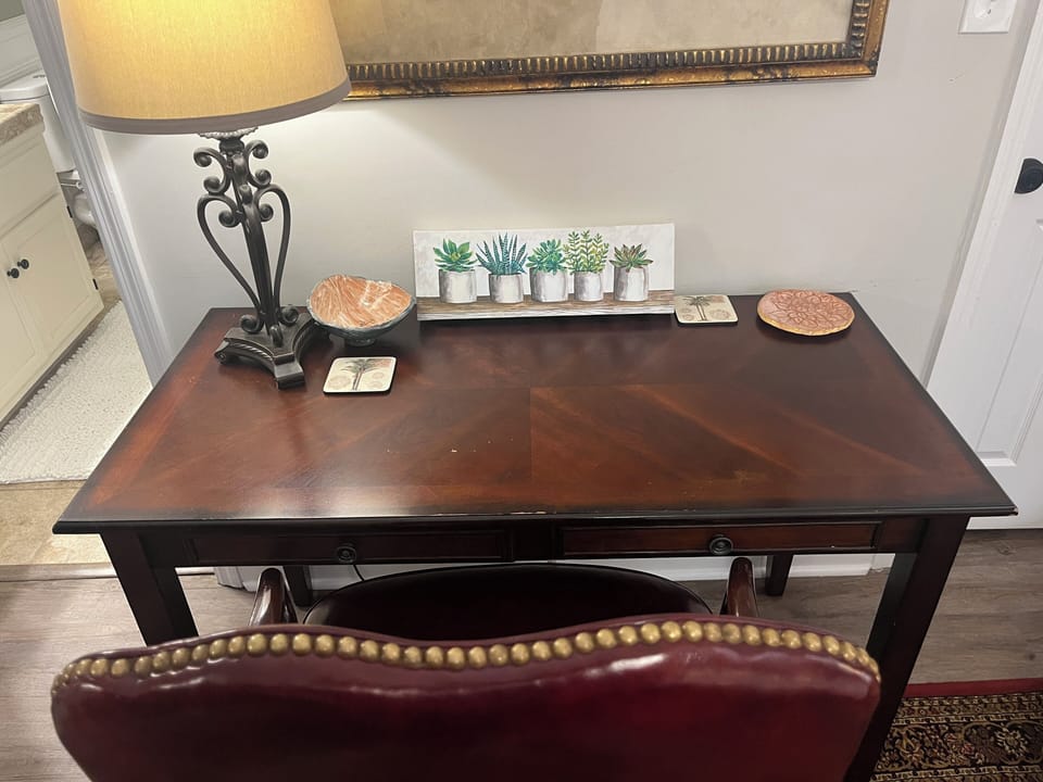 Master bedroom features a comfy king bed, sitting area, desk, & private bath
