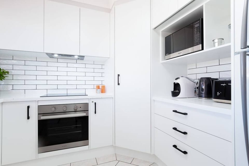 Kitchen with Nespesso coffee pod machine and other appliances.