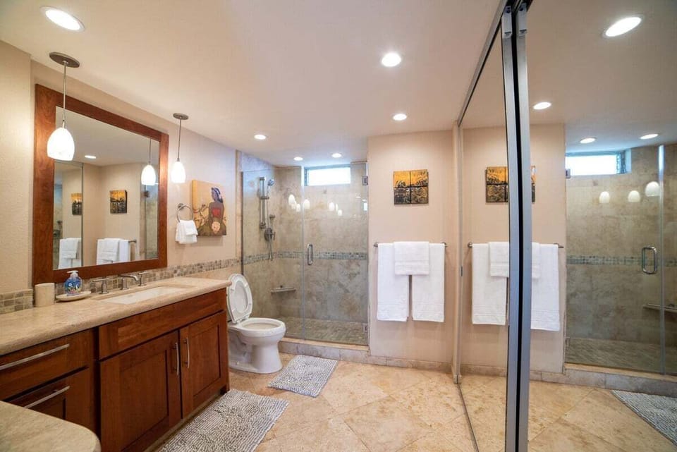 A bright, well-appointed bathroom features a sleek walk‑in shower and warm finishes for a comfortable retreat.