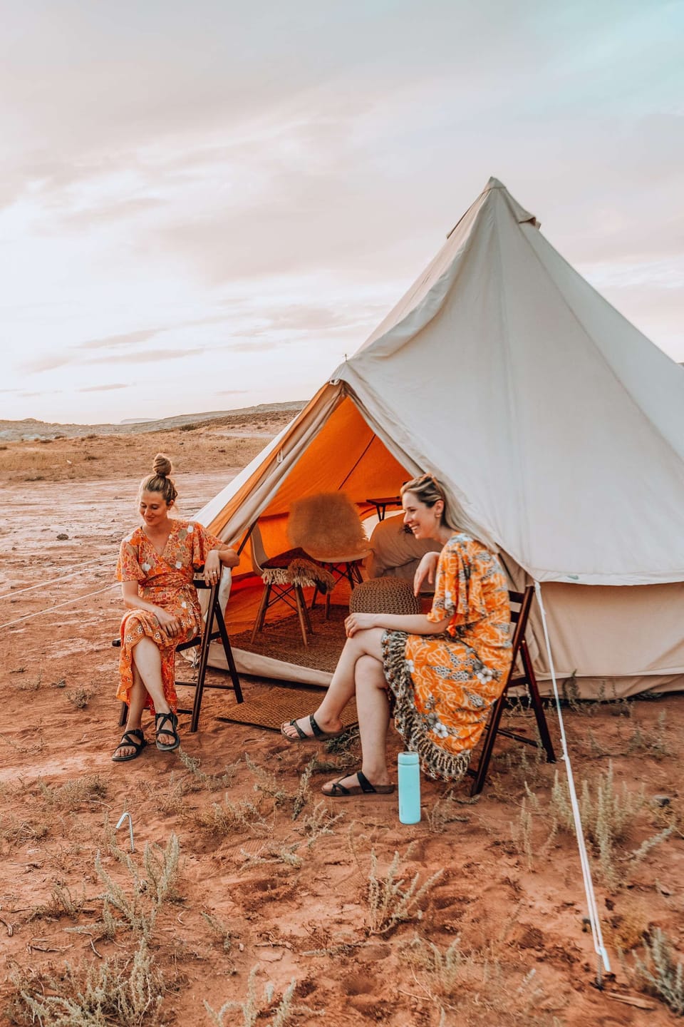 Guests enjoying a few moments outside sitting in our wooden folding chairs provided in each tent.