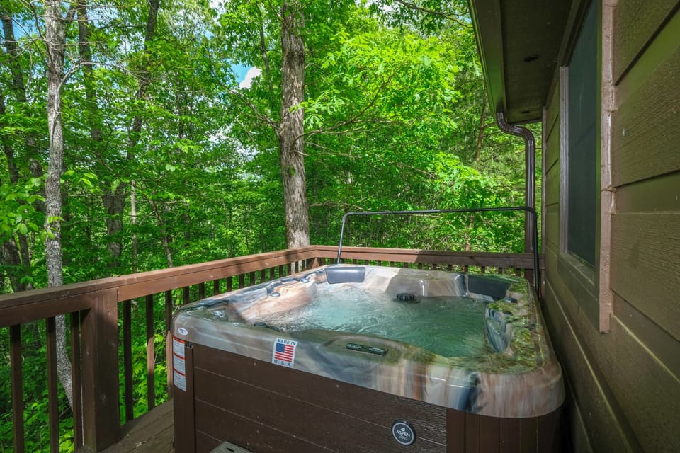 Hot tub on the private back deck overlooking the wooded lot.
