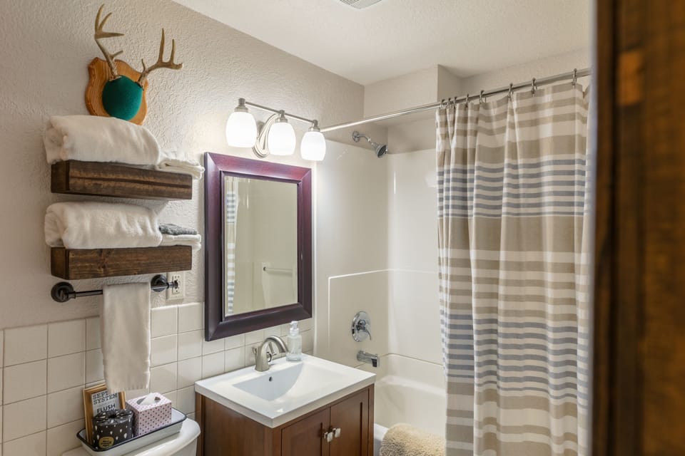 Main floor full bathroom with dual access to hallway and main floor bedroom