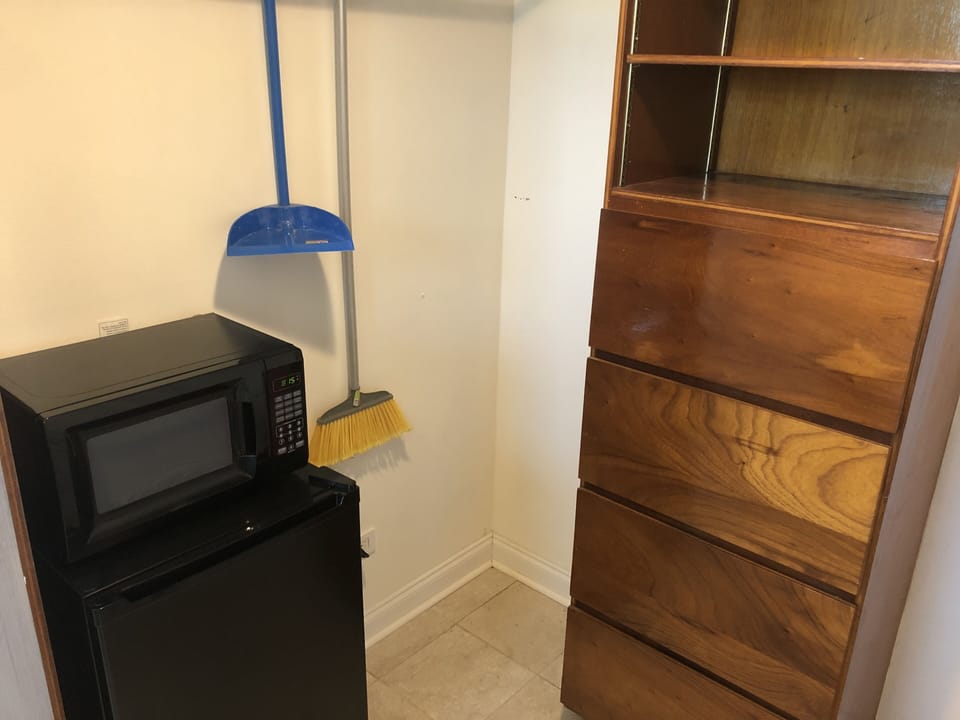 Microwave, mini refrigerator and broom with dust pan