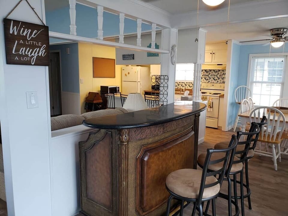 Bar area with stools for serving your favorite beverages. Chairs face living room and TV
